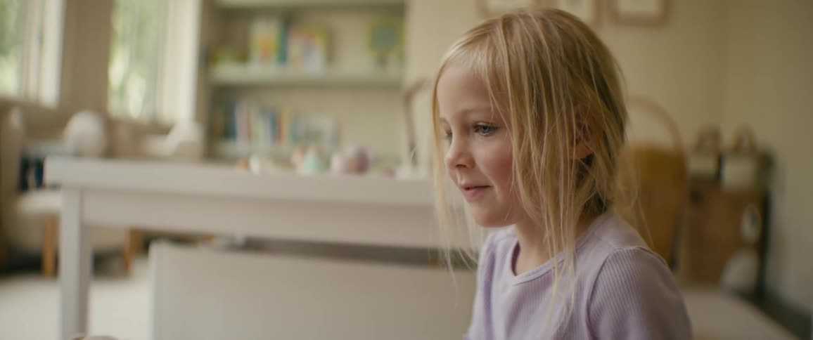 A happy young girl is delighted as she plays with a Winnie the Pooh jack-in-the-box toy in her sunlit playroom