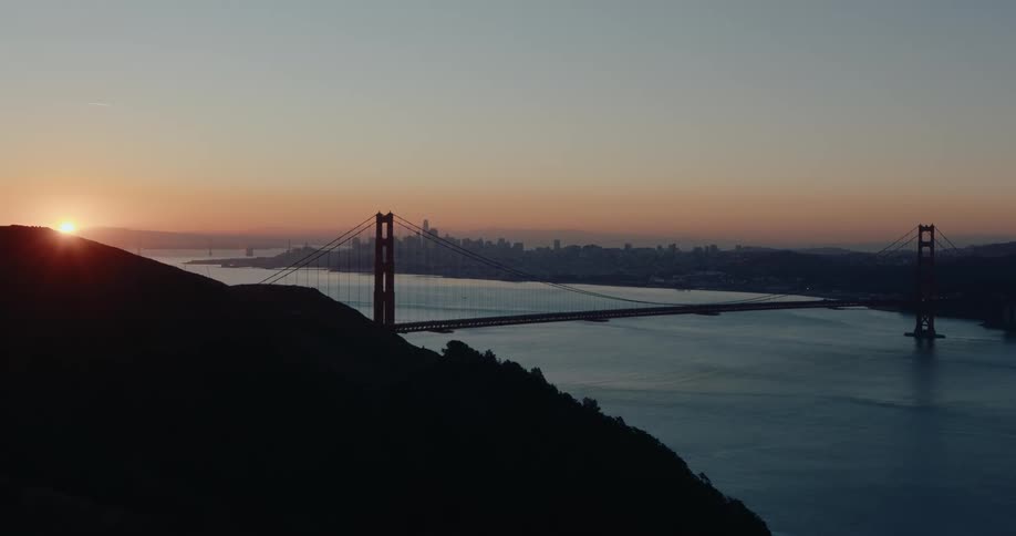 A breathtaking sunrise over the Golden Gate Bridge with the San Francisco skyline silhouetted in the distance