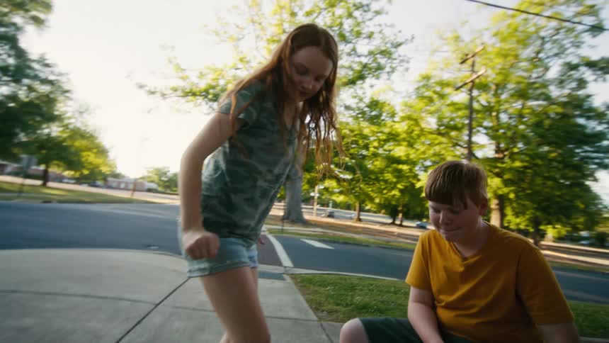 Kids have fun stomping on and popping their empty juice pouches on a sidewalk