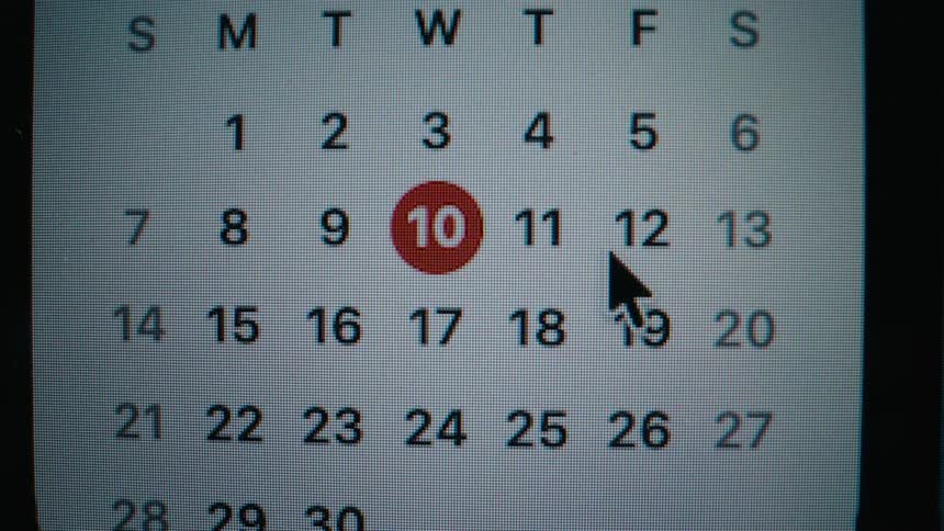 A close-up shot of a computer mouse cursor browsing dates on a digital calendar with the current day circled in red