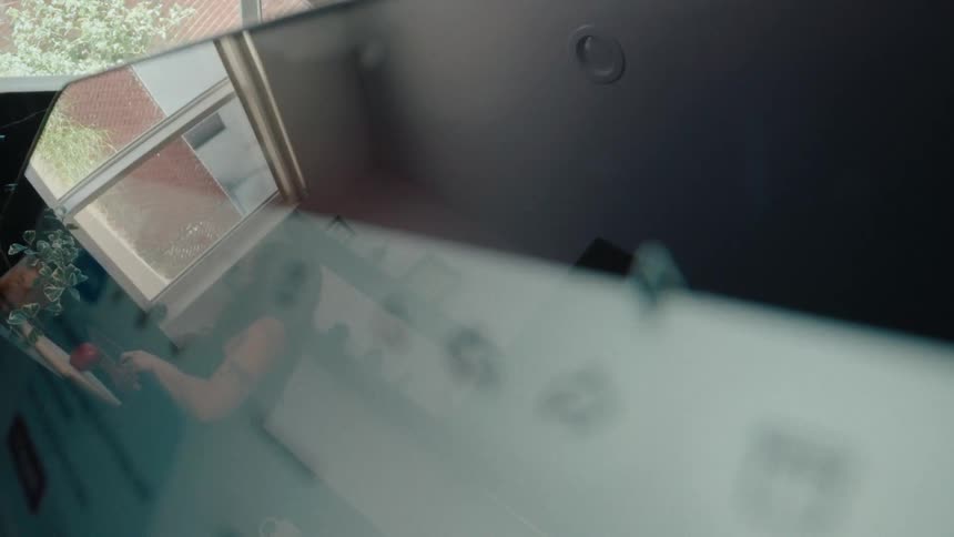 A computer cursor hovers over a send icon in an extreme close-up, with the user's reflection visible on the screen