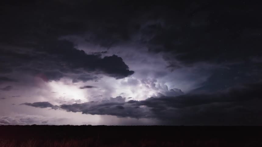 A storm flares in the sky over the field