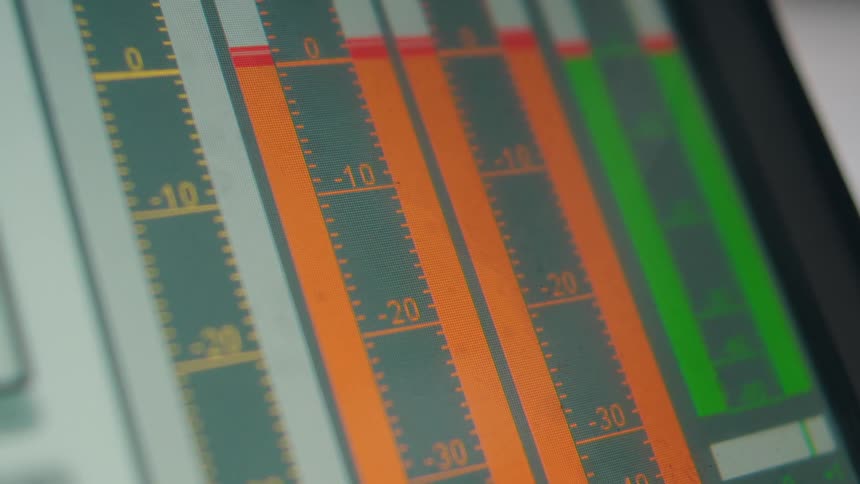 A close-up of a digital audio mixing console screen showing fluctuating sound level meters during a recording session