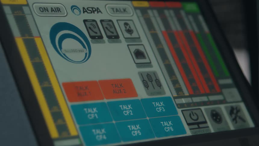 Close-up on a digital audio mixing console with active level meters and flashing lights
