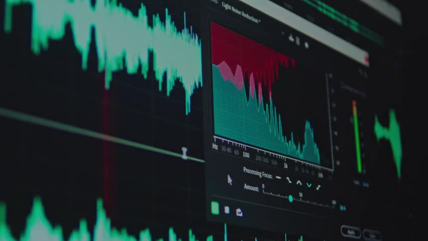 A sound engineer uses a digital audio workstation to perform light noise reduction on a track