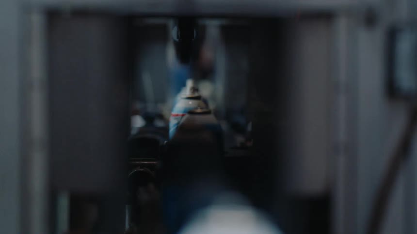 Aerosol cans travel down a conveyor belt on an automated factory production line