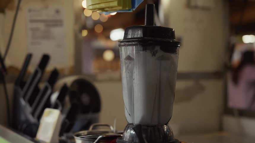 Close-up of a white liquid being blended in a kitchen setting