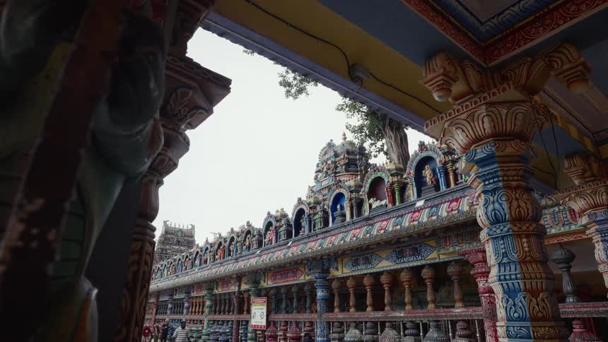 Colorful carved pillars and statues adorn the facade of a traditional Hindu temple