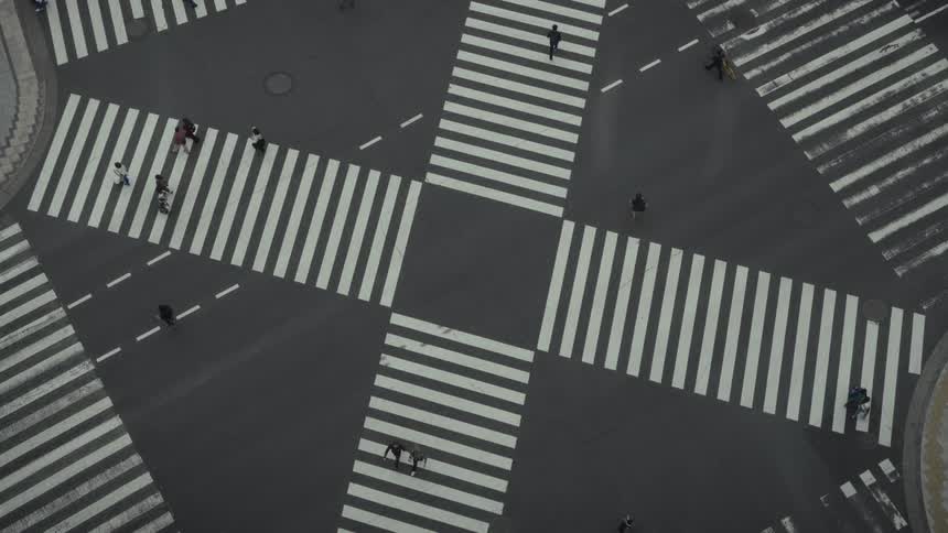 A minimalist high-angle view shows pedestrians crossing the iconic Ginza intersection in Tokyo, Japan, until the street is empty