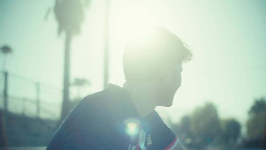 Inspirational slow motion shot of a young coach clapping and encouraging his team from the sidelines on a sunny day
