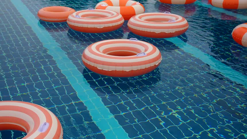 A collection of colorful inflatable rings floats peacefully in a clear blue swimming pool