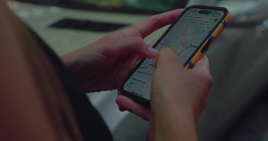 A close-up shot of a person's hands navigating and exploring a map on a smartphone