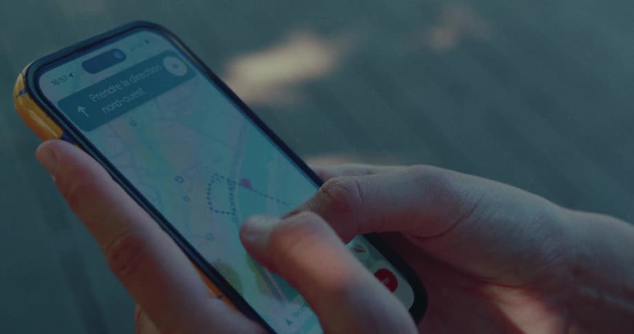 Close-up of a person's hands navigating a digital map on a smartphone to follow a planned route