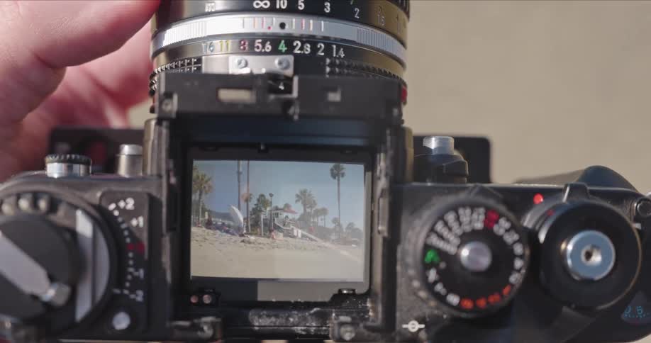 Point of view shot looking through the viewfinder of a vintage film camera to frame a sunny beach scene