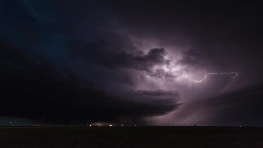 A thunderstorm flashes over plains at night
