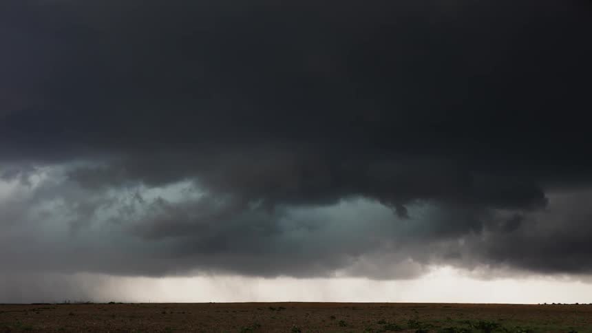 Storm clouds form over an open field