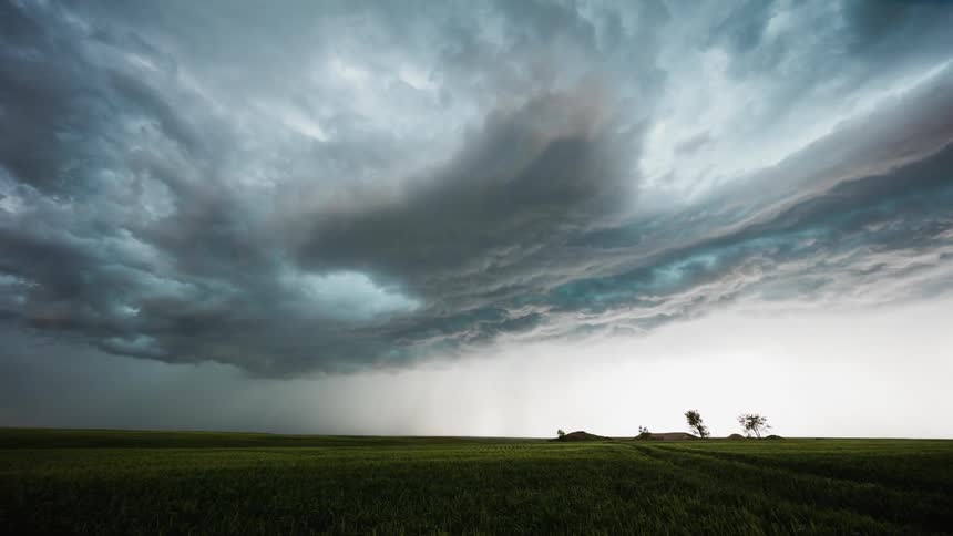 Clouds forming and flowing in sky over farm
