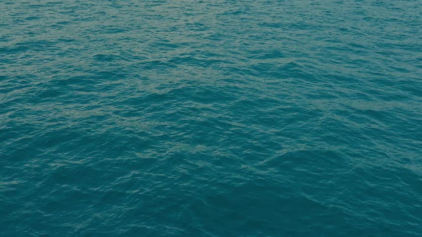Deep turquoise ocean water gently ripples across the surface in a calming, endless motion