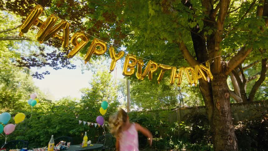 A group of energetic kids create chaos at a sunny backyard birthday party, knocking down the golden 'Happy Birthday' banner