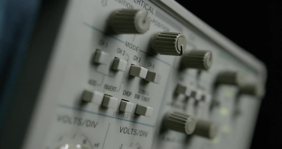 Shadows and lights move across a panel with man knobs and buttons