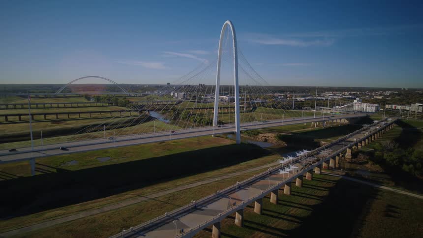 An aerial dolly shot pushes in towards the Margaret Hunt Hill Bridge in Dallas, Texas, on a bright, sunny morning