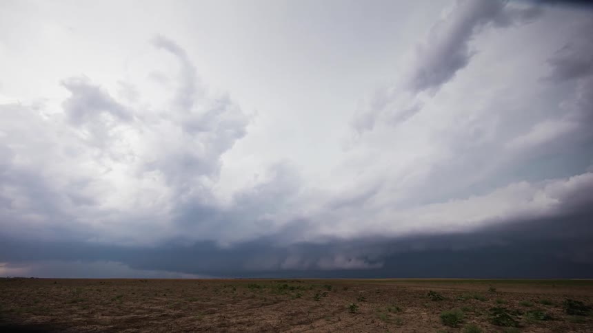 Storm clouds spin and move past a field