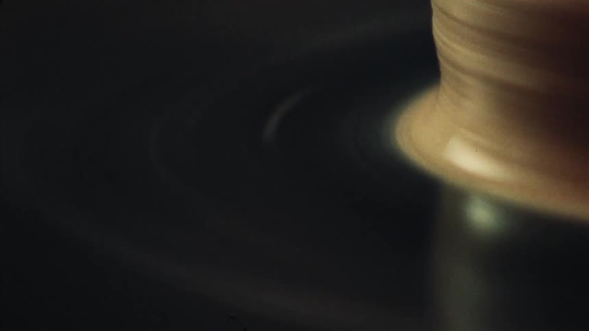 An abstract close-up shot of a spool of thread spinning on a textile machine