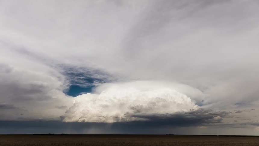 Clouds move over a flat landscape during the day