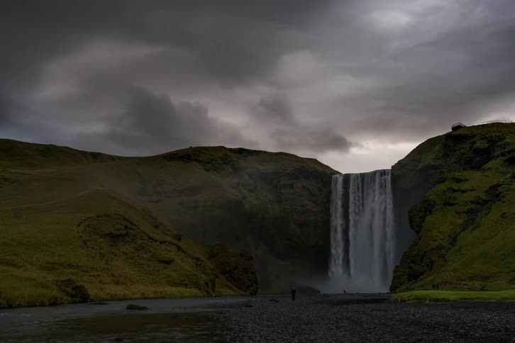 The waterfall is pouring down on a cloudy day