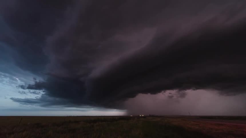 Storm clouds and lighting move over a plain