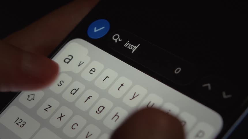 Close up of a person typing the word 'install' in the search bar of a smartphone