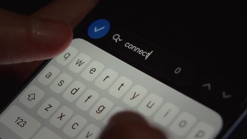 A macro close-up of a person typing the word 'connect' on a smartphone keyboard search bar