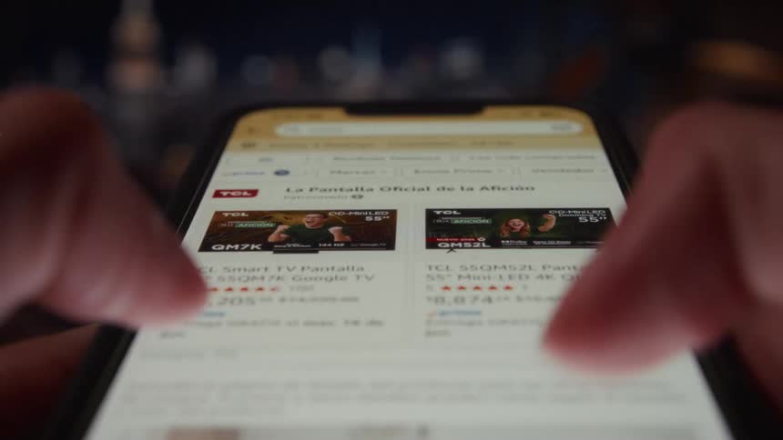 A fast-paced, close-up view of a person rapidly typing and scrolling through an online shopping website on their smartphone at night