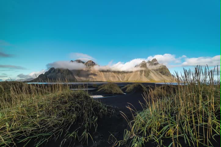 Time lapse of clouds billowing over mountains on a clear day