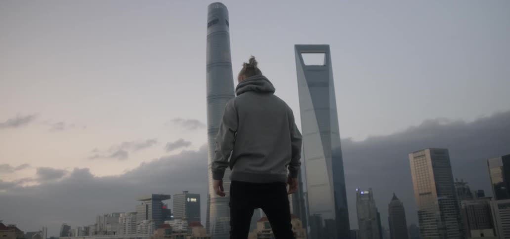 A man standing outside looks out over the city