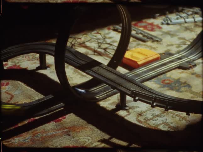 Nostalgic vintage footage shows colorful toy cars racing on a slot car track with a loop