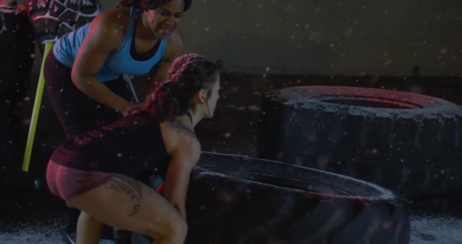 A woman flips a tire as it snows