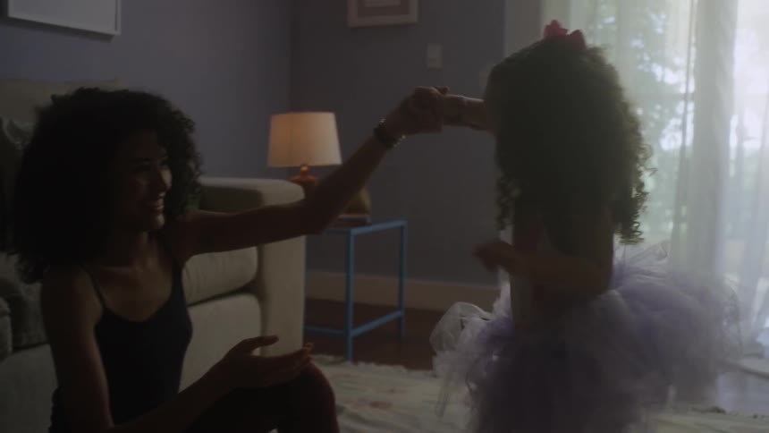 A woman and girl play in the living room