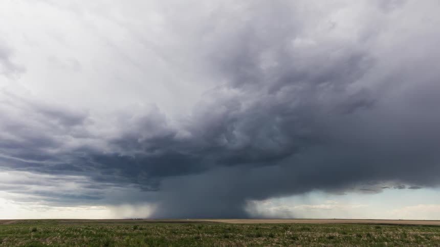 Storm clouds gather and circle over a field