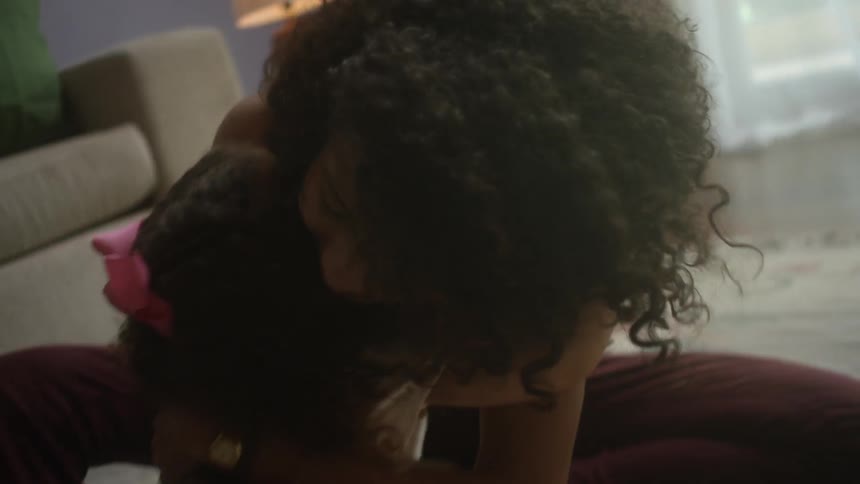 A woman hugs a little girl