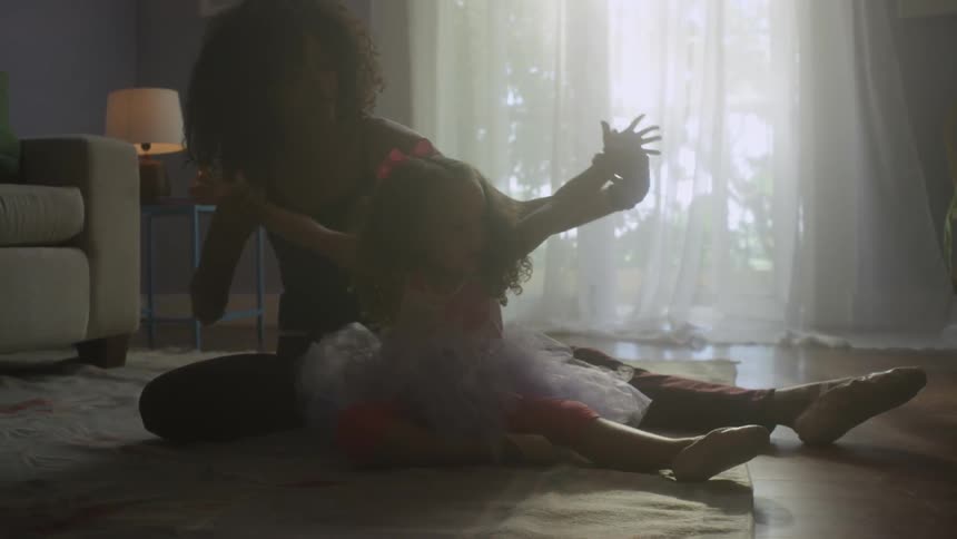 A woman and her toddler child practice dance movements