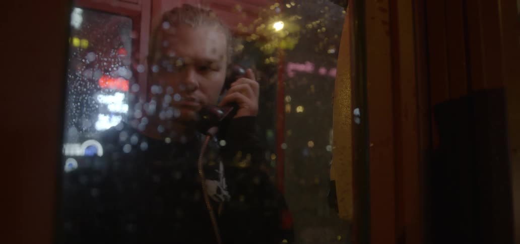 A man enters a phone booth calls someone and leaves