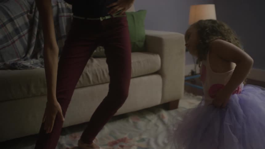 Woman and child dance in a living room