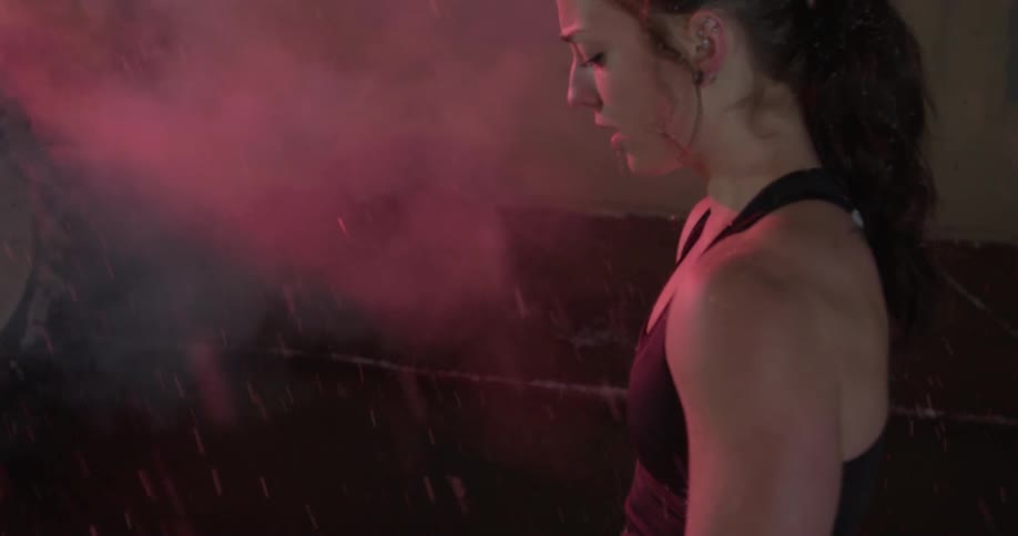 A woman in workout clothes stands outside in the snow at night