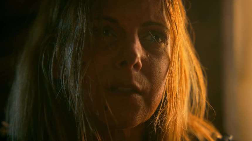 Close-up of a woman's face filled with profound sadness as she cries in a dimly lit, dramatic setting
