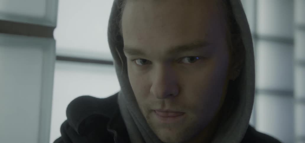 A man with a hood looks forward
