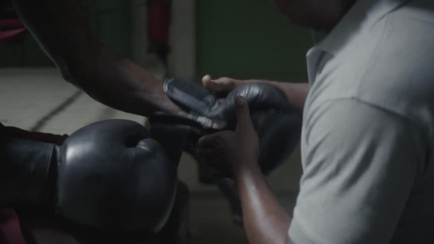 Person straps boxing gloves on another person's hands