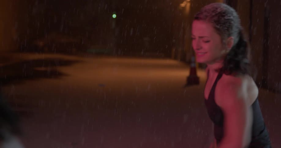 A woman swinging a sledgehammer outside in the snow