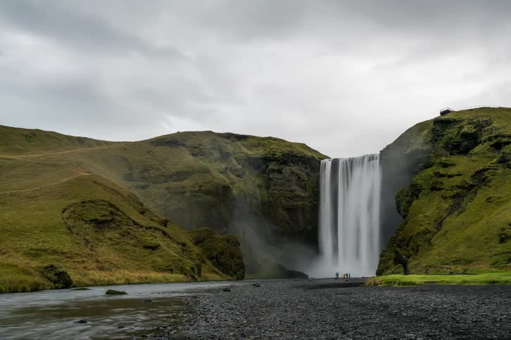 People view and photograph a waterfall