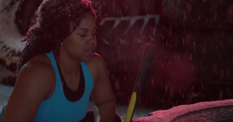 A female in athletic clothing is squatting outside in the snow breathing heavy